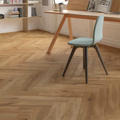 Suelo de madera en patrón de espiga, con una silla azul clara y una mesa de trabajo.