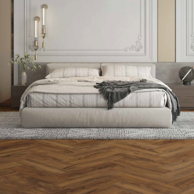 Cama grande con edredón y manta, decoración minimalista y suelo de madera.