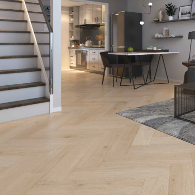 Interior de una casa con escaleras, cocina moderna y suelo de madera en patrón en espiga.
