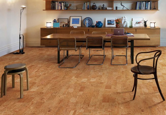 Sala con mesa y sillas, iluminación suave y suelo de madera clara.
